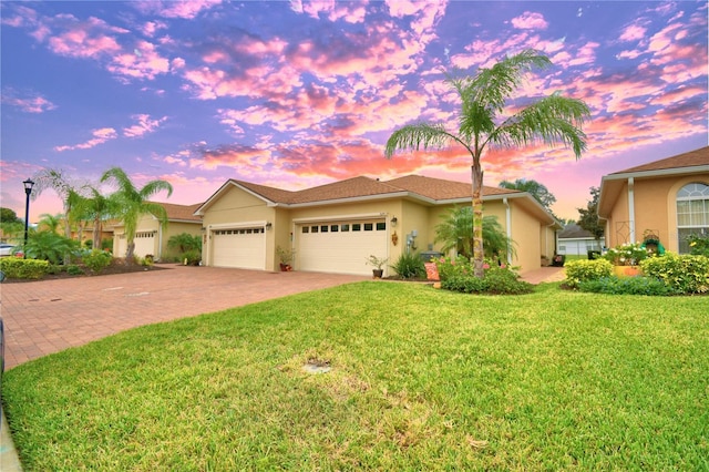 view of front facade with a lawn and a garage