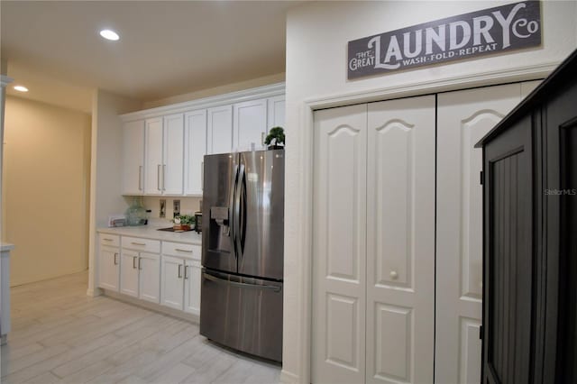 kitchen featuring white cabinetry, stainless steel fridge, and light wood-type flooring