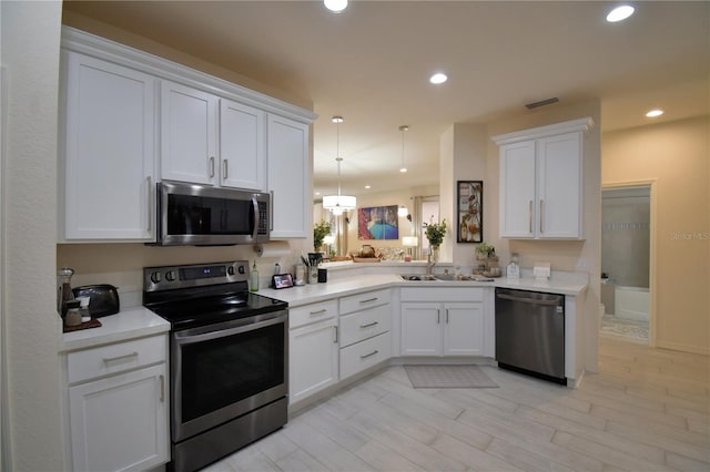 1644 Linz Ct, Winter Haven, FL 33884 - kitchen featuring stainless steel appliances, a sink, white cabinets, light countertops, and recessed lighting