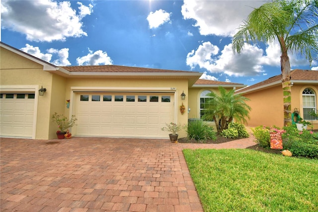 1644 Linz Ct, Winter Haven, FL 33884 - view of front facade with decorative driveway, stucco siding, a garage, and a front yard