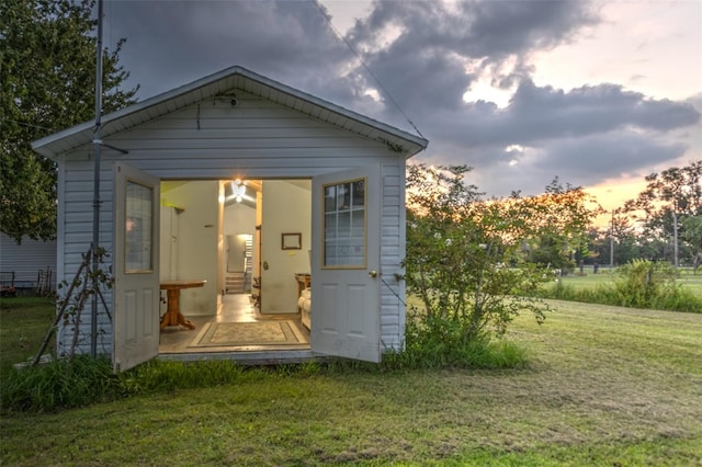 back house at dusk featuring a yard