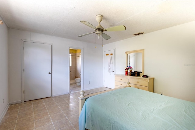 tiled bedroom featuring ensuite bathroom, ceiling fan, and a textured ceiling