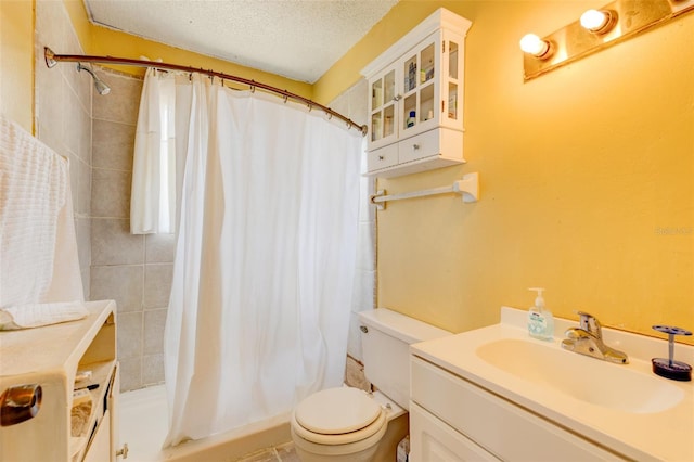 bathroom with a shower with curtain, vanity, a textured ceiling, and toilet