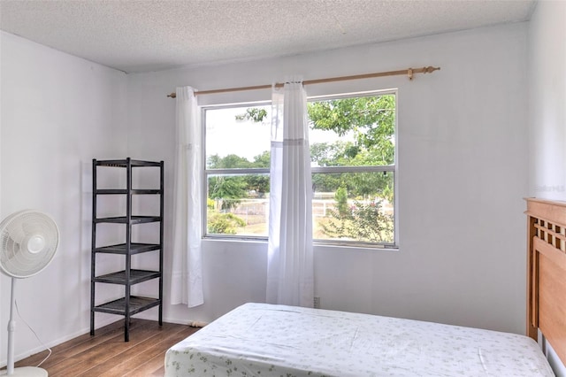 bedroom with hardwood / wood-style flooring and a textured ceiling