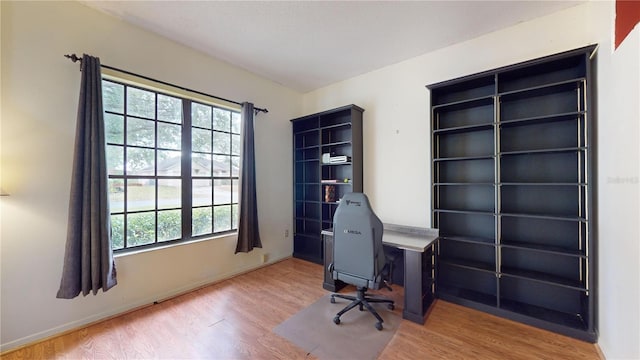 unfurnished office with hardwood / wood-style floors and a healthy amount of sunlight