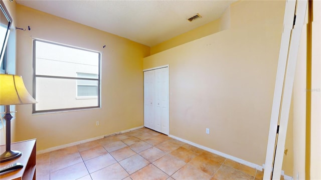 unfurnished bedroom with a closet and light tile patterned floors