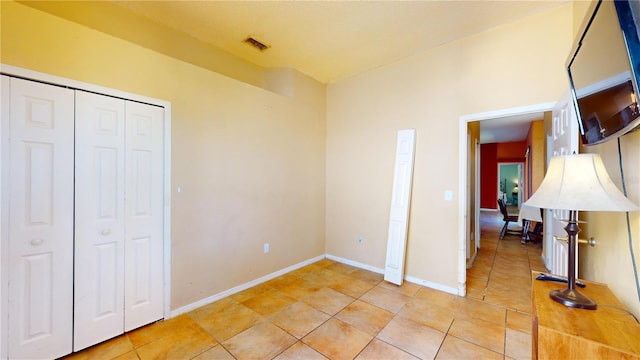 unfurnished bedroom with light tile patterned floors and a closet