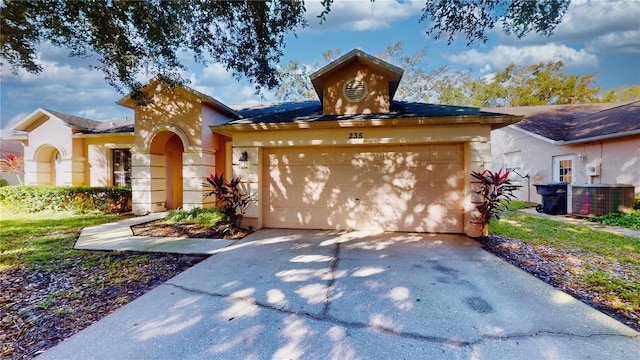 view of front of property featuring a garage and central AC