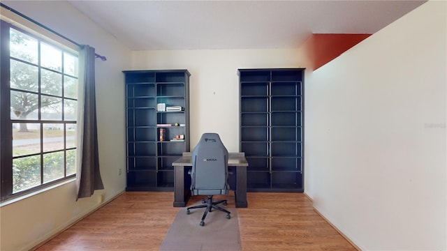 home office with light hardwood / wood-style flooring