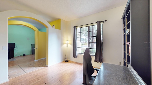 unfurnished office featuring a textured ceiling and hardwood / wood-style flooring