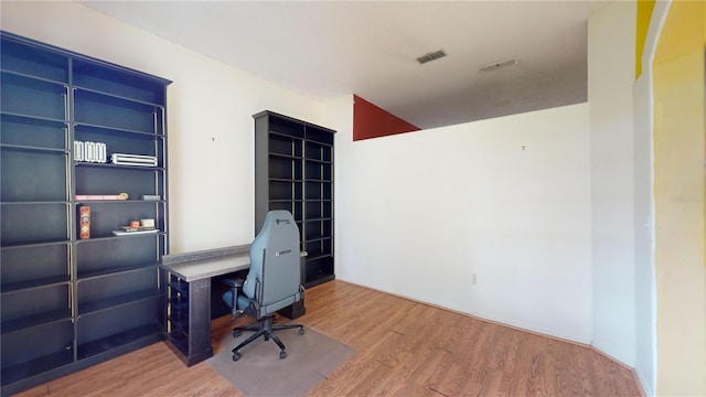 home office featuring wood-type flooring and built in features