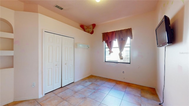 unfurnished bedroom with a closet and light tile patterned floors