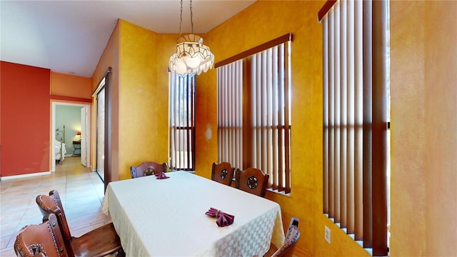 tiled dining space featuring a chandelier