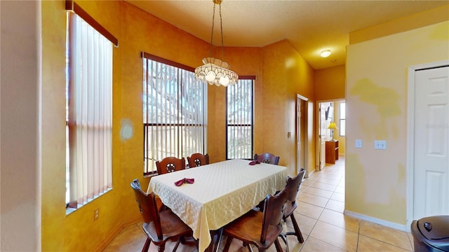 dining space featuring light tile patterned floors and a notable chandelier