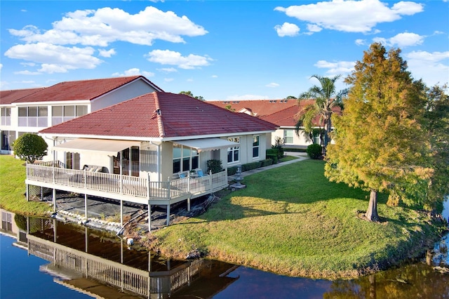 rear view of property with a lawn and a water view