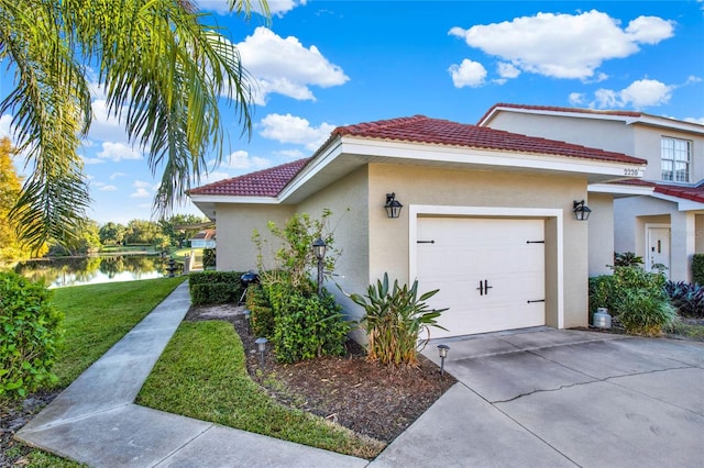 view of home's exterior with a lawn, a garage, and a water view