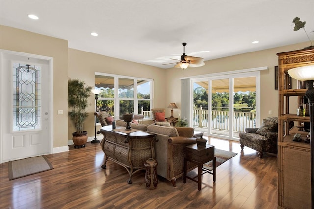 living room with ceiling fan and dark hardwood / wood-style flooring