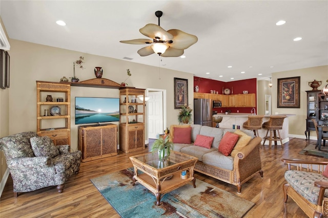 living room with ceiling fan and hardwood / wood-style flooring