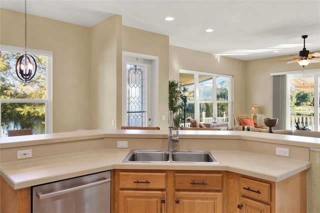 kitchen with ceiling fan with notable chandelier, stainless steel dishwasher, and sink