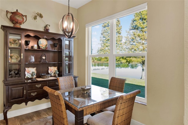 dining space featuring a water view and hardwood / wood-style flooring