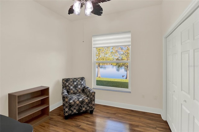 living area featuring dark hardwood / wood-style floors and ceiling fan