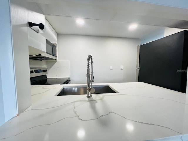 7108 Waterside Dr Unit 103, Tampa, FL 33617 - kitchen with appliances with stainless steel finishes, a sink, light stone counters, and recessed lighting
