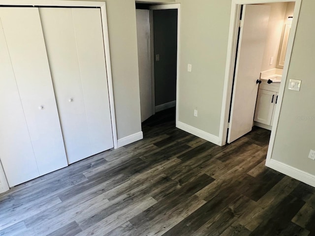 7108 Waterside Dr Unit 103, Tampa, FL 33617 - unfurnished bedroom featuring baseboards, a closet, and dark wood-style flooring