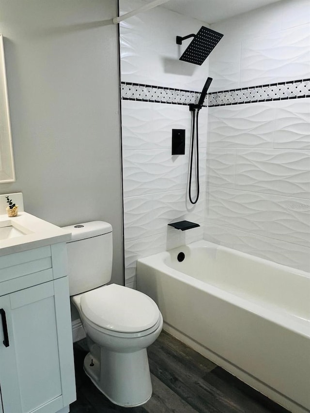 full bathroom with hardwood / wood-style floors, vanity, toilet, and tiled shower / bath combo