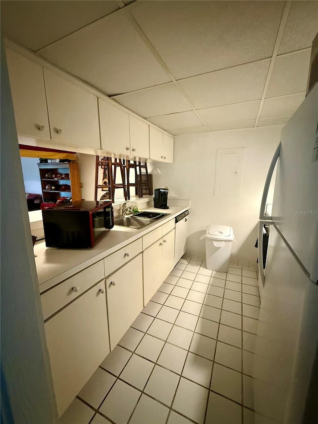 kitchen featuring a paneled ceiling, dishwasher, sink, and white cabinets