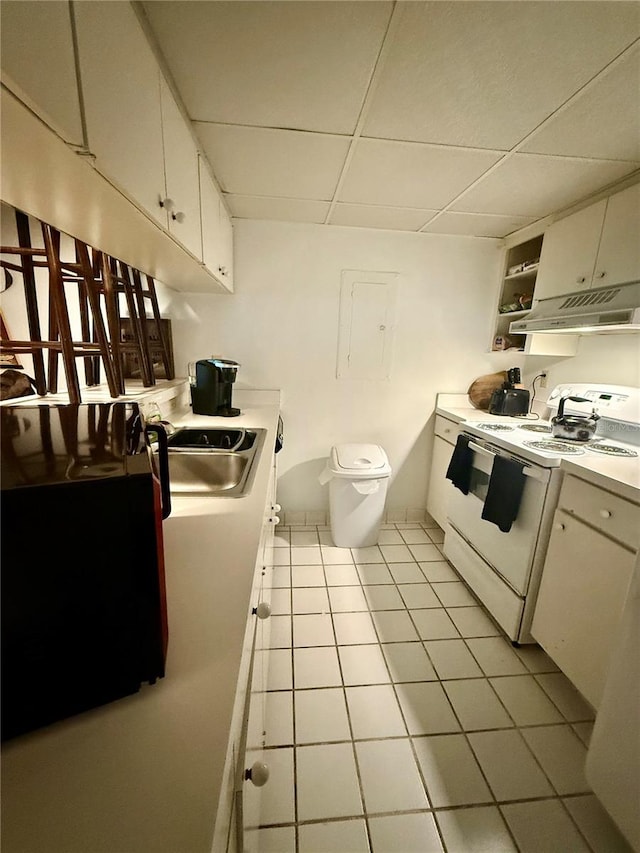 kitchen with a paneled ceiling, white stove, white cabinets, sink, and light tile patterned flooring