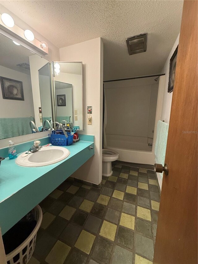 full bathroom with toilet, vanity, a textured ceiling, and washtub / shower combination