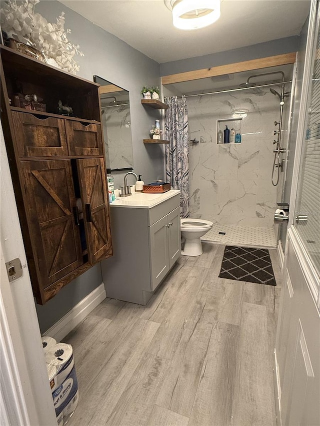 bathroom featuring vanity, toilet, hardwood / wood-style floors, and walk in shower