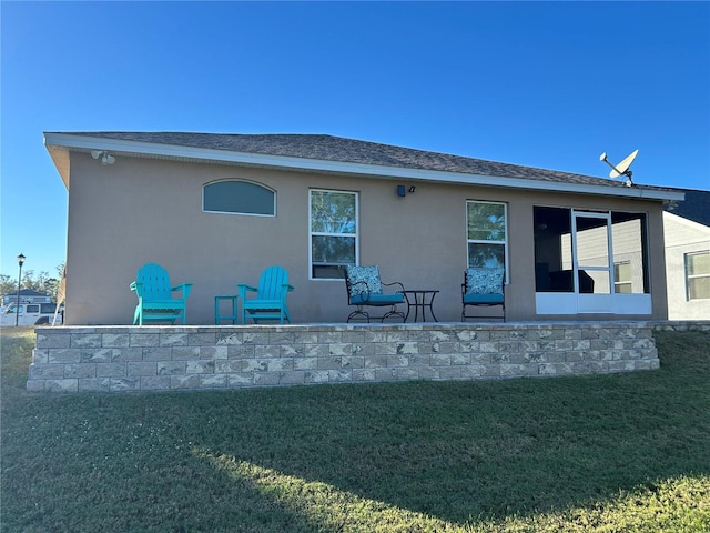 rear view of house featuring a patio and a yard