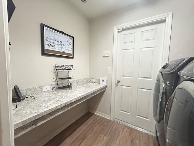 washroom with washing machine and dryer and hardwood / wood-style flooring