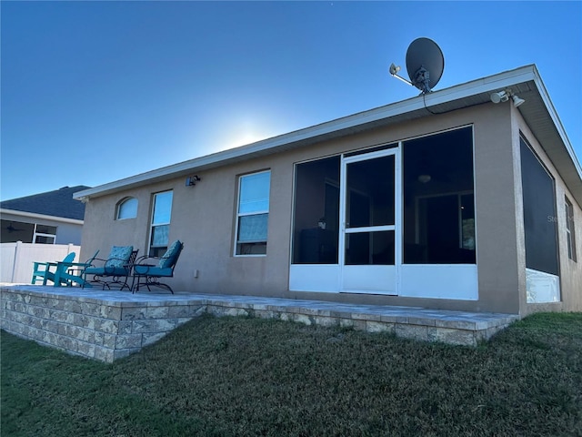 rear view of property with a patio, a sunroom, and a lawn