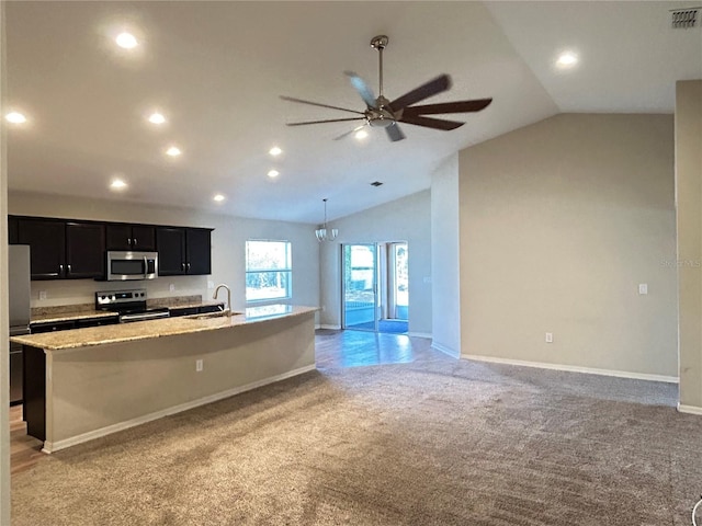 kitchen featuring light colored carpet, stainless steel appliances, a kitchen island with sink, and sink