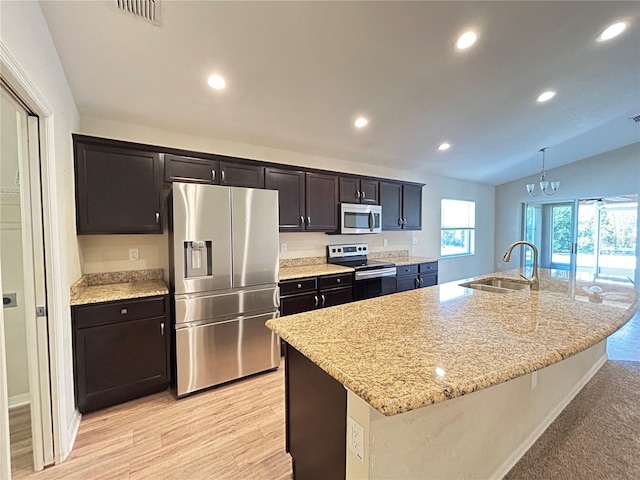 kitchen with sink, stainless steel appliances, an island with sink, and pendant lighting