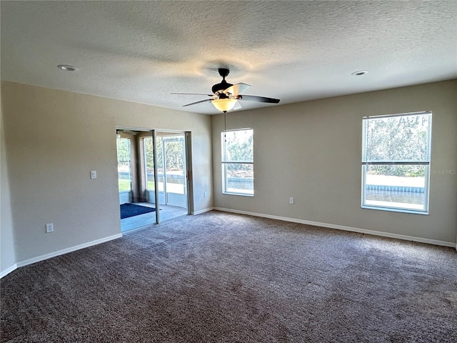 carpeted spare room featuring a textured ceiling and ceiling fan