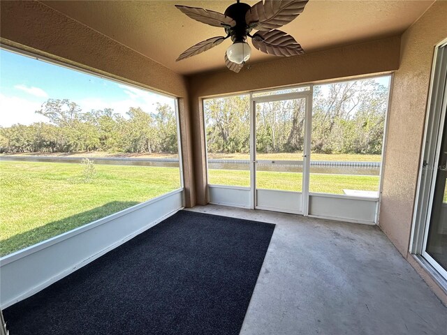 unfurnished sunroom featuring ceiling fan