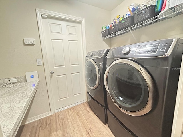 laundry area featuring light hardwood / wood-style flooring and washer and clothes dryer