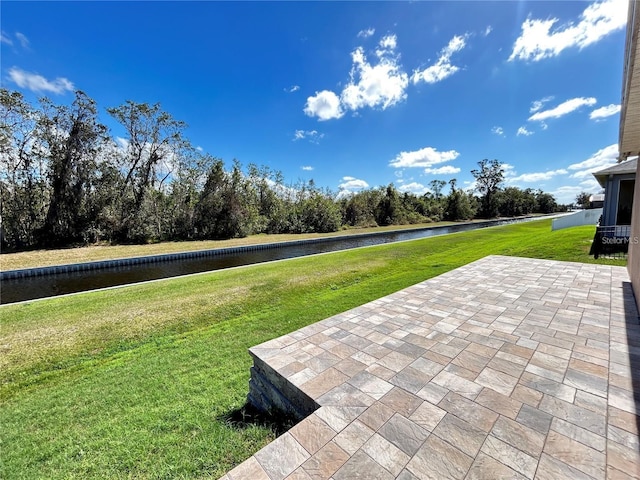 view of yard with a water view and a patio