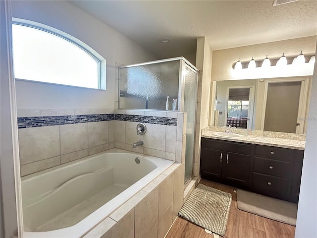 bathroom with separate shower and tub, hardwood / wood-style flooring, a wealth of natural light, and vanity