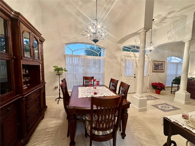 dining space with decorative columns, light carpet, plenty of natural light, and an inviting chandelier