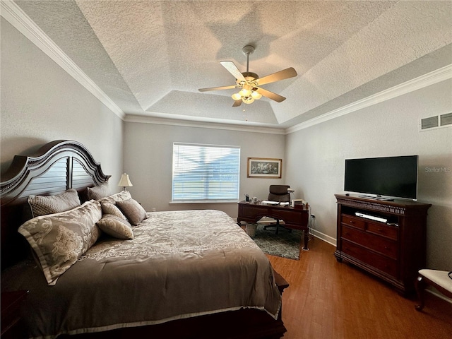 bedroom with a textured ceiling, a raised ceiling, ceiling fan, crown molding, and hardwood / wood-style flooring