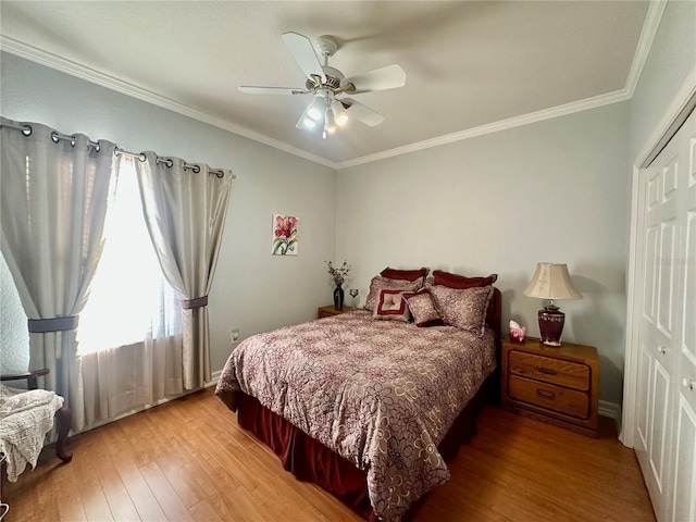 bedroom featuring ceiling fan, wood-type flooring, crown molding, and a closet