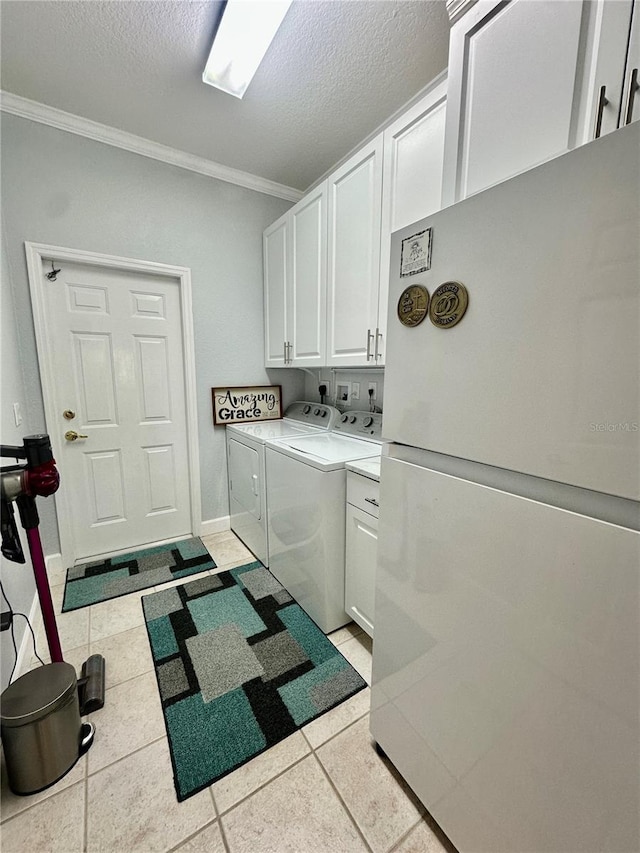 laundry area featuring cabinets, independent washer and dryer, light tile patterned floors, and ornamental molding