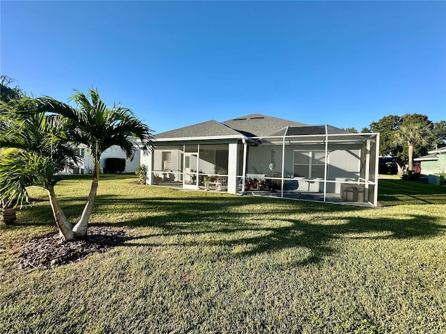 rear view of house featuring a lawn and a lanai