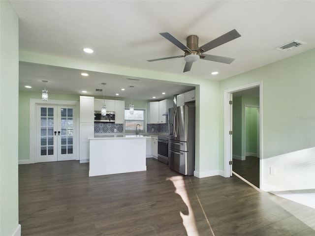 kitchen featuring french doors, decorative light fixtures, a kitchen island, stainless steel appliances, and white cabinets