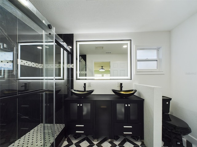 bathroom featuring vanity, toilet, and a shower with door