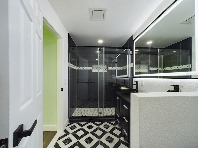 bathroom featuring vanity and an enclosed shower